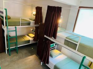 埃拉Downtown Hostel Ella的客房设有三张双层床和一扇窗户。