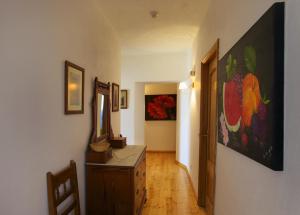 帕德内Hospedaria Moiras Encantadas的走廊上挂有梳妆台和墙上的绘画作品