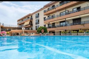 普拉加德阿罗Apartamento céntrico Playa de Aro con piscina.的大楼前的大型游泳池