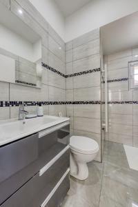 埃库昂Joli Appartement de vacances的白色的浴室设有卫生间和水槽。