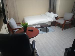 NarokNyatana suite (Fully furnished apartments)的小房间设有一张床、一张桌子和椅子