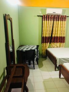 阿努拉德普勒River Garden Hotel Anuradhapura的配有床、桌子和椅子的房间