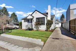 温哥华Picture Perfect Bungalow in the heart of DT Vancouver的白色的房子,有栅栏和院子