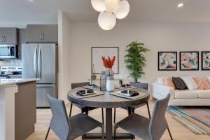 卡尔加里Luxurious Modern Home With King Bed & Office的厨房以及带桌椅的起居室。