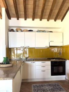 圣托斯特凡诺港BB24 - Cottage il Puntino的厨房配有白色橱柜和炉灶烤箱。