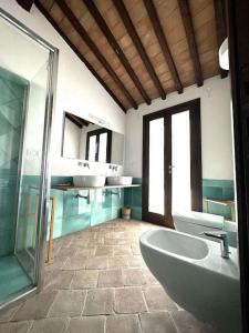 圣托斯特凡诺港BB24 - Cottage il Puntino的一间带两个盥洗盆、浴缸和卫生间的浴室