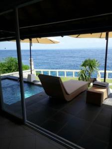 蓝梦岛Nusa Lembongan Villa Shambala的露台享有海景,配有遮阳伞。