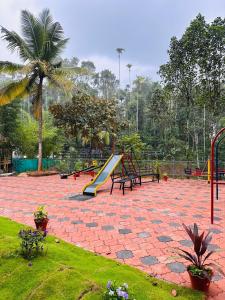 瓦亚纳德Andoor private pool的公园设有带滑梯和长椅的游乐场