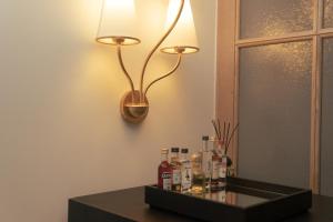 伦敦Magda Boutique Rooms的桌子上的一盏灯,上面装有瓶子