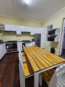 Mount Road11 on Elizabeth的厨房配有木桌和白色橱柜。