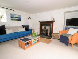 LochsBeech Cottage的客厅设有蓝色的沙发和壁炉