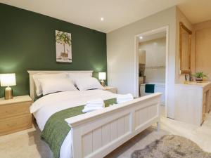 尤托克西特2 Dove Cottage的一间卧室设有一张大床和绿色的墙壁