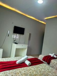 巴雷里尼亚斯Marcone Lima - Chalés的配有两张床铺的客房,墙上配有电视