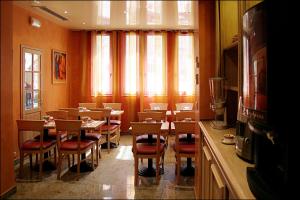 巴黎格兰德酒店的一间带桌椅的用餐室和窗户。