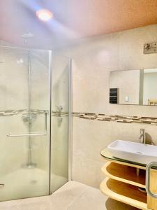 墨西哥城Hostal Boutique de Venecia的一间带玻璃淋浴和水槽的浴室