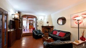拉达-因基安蒂Angolino的客厅配有黑色皮革家具和壁炉