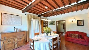 拉达-因基安蒂Angolino的一间带桌子和红色沙发的用餐室