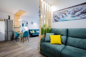 圣米格尔德阿沃纳GP127 apartman Tenerife的一间带绿色沙发的客厅和一间厨房