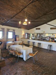 TorilHotel Rural Portilla de Monfragüe的一间带桌椅的用餐室和一间酒吧
