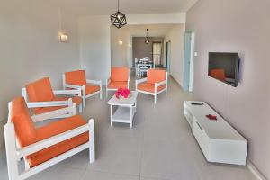 蒙舒瓦西OceanBreeze Apartments Mont Choisy的一间配备有橙色椅子和电视的等候室