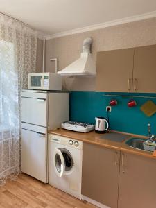 阿拉木图Квартира -Атакент的厨房配有洗衣机和水槽
