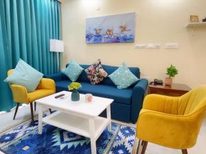 达波林Luxe 2BHK by Coral BnB with Pool access的客厅配有蓝色的沙发和两把椅子
