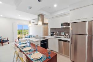 棕榈滩Bocobay Aracari Condo Hotel的厨房配有餐桌和冰箱