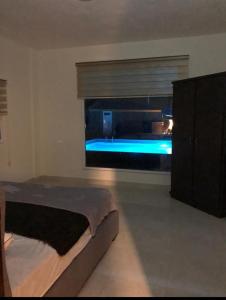 Al KarāmahCali Chalet的一间卧室设有一张床和一个带浴缸的窗户。