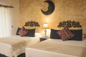 危地马拉安地瓜月光女神酒店的墙上有月牙的房间,有两张床