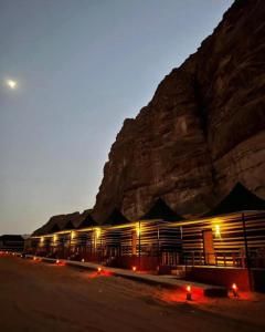 瓦迪拉姆SOlARIS WADI RUM CAMP的一座晚上在山前的建筑