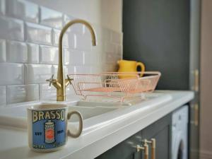圣伦纳兹Gensing Lodge - A Beautiful Artistic Maisonette的水槽旁厨房柜台上的杯子