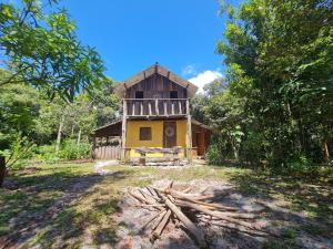 伊塔卡雷Que Brota Do Chão的森林中间的一座黄色小建筑