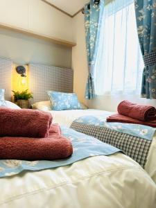 斯卡伯勒Los Jameos的两张床铺,配有蓝色窗帘和红色毛巾
