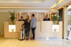布宜诺斯艾利斯M Concept Hotel的站在大堂的男人和女人,手提箱