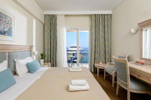 萨索斯Hotel Timoleon的配有一张床、一张书桌和一扇窗户的酒店客房
