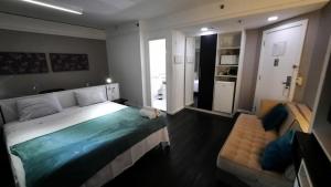 圣保罗Flat Hotel av Macuco São Paulo Ibirapuera UH-2710的一间卧室配有一张大床和一张沙发