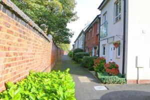 曼彻斯特Luxurious Townhouse In Central Manchester的砖墙和建筑物旁的一条人行道