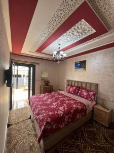 海尼夫拉APPART HOTEL OUED EDDAHAB的一间卧室配有一张红色床单和天花板