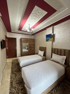 海尼夫拉APPART HOTEL OUED EDDAHAB的配有两张床的酒店客房