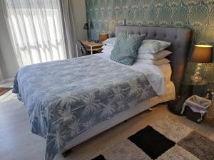 芒格努伊山Sunbrae Beach Sanctuary free high Fibre wifi的一间卧室配有一张带蓝色棉被的大床