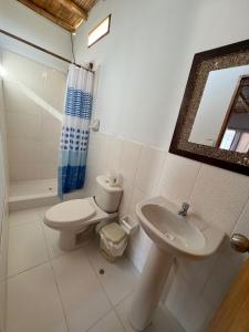 曼克拉Casa Hotel Pacific Máncora - Piscina & Playa的一间带卫生间、水槽和镜子的浴室