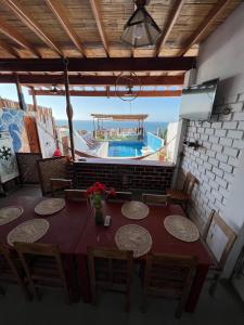 曼克拉Casa Hotel Pacific Máncora - Piscina & Playa的一间带桌椅的用餐室和一个游泳池