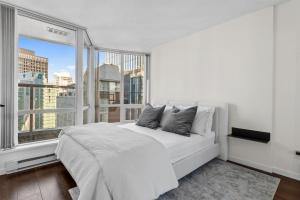 温哥华Downtown Luxury 1BR Coal Harbour的卧室设有白色的床和大窗户