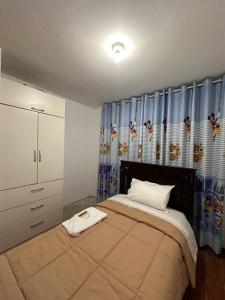 皮斯科Casa San Andrés Arenas I的一间卧室配有一张带蓝色窗帘的大床