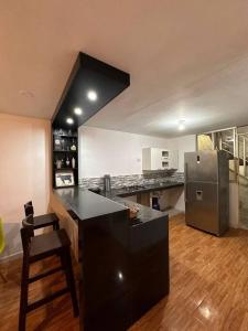 皮斯科Casa San Andrés Arenas I的厨房配有黑色柜台和冰箱。
