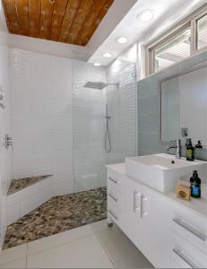 棕榈泉On The Rox- Luxury Refreshing Mid-Century Mod- Pool, Spa, Firepit, Outdoor Kitchen & More的白色的浴室设有水槽和淋浴。