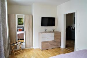 柯尼希施泰因易北Luxuriöse Ferienwohnungen的一间卧室配有梳妆台和墙上的电视