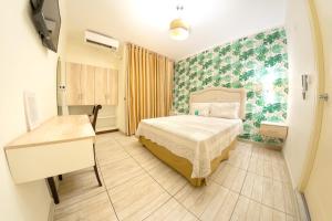 廷戈玛丽亚Hotel Natural Green Lounge的一间卧室配有一张床和一张书桌