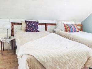 斯特伦斯塔德The Blomsholm Cabin的配有2张床的带白色床单和枕头的客房