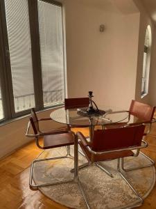 比托拉Luxury apartment的一间设有玻璃桌和椅子的用餐室